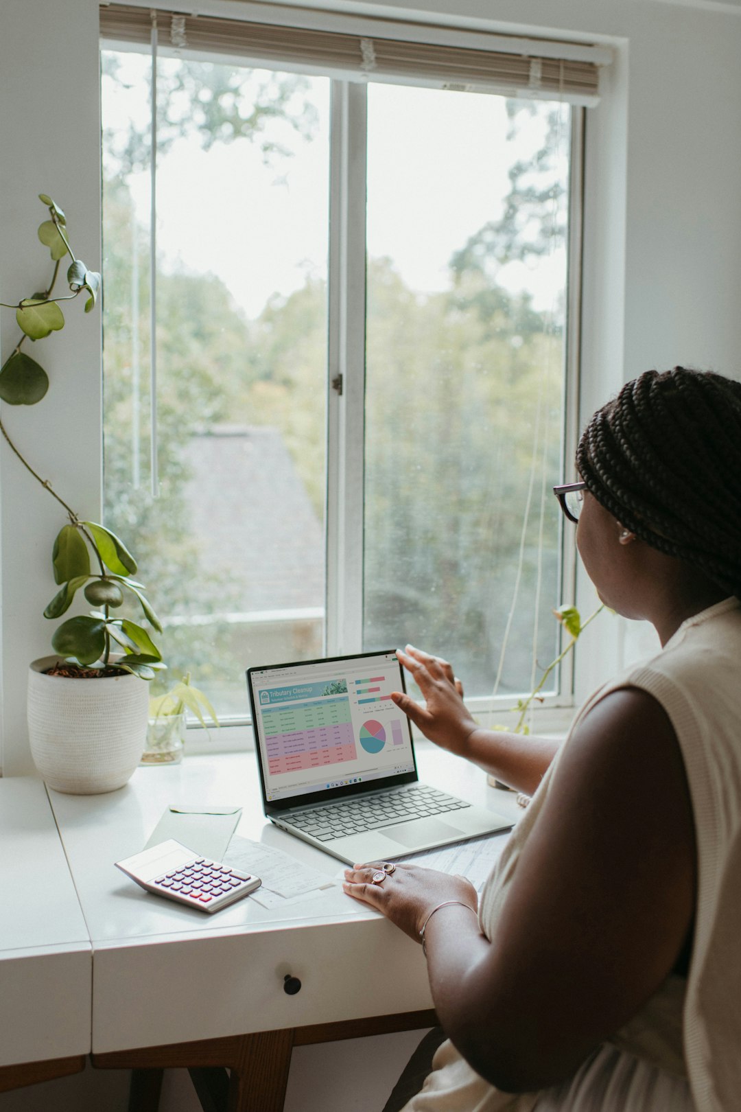 a-woman-sitting-at-a-table-using-a-laptop-computer-ktfmwxkf5bq